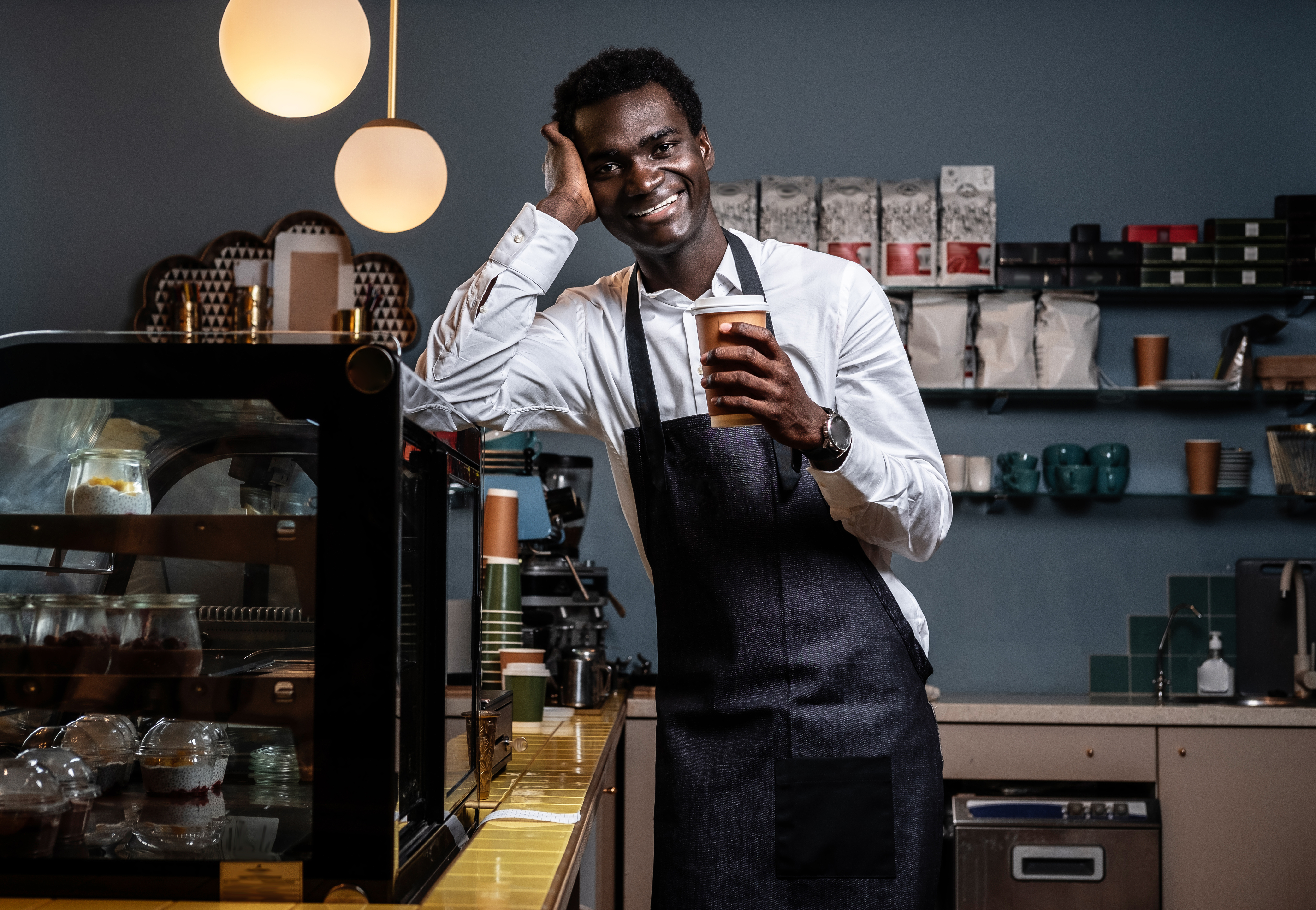 African business owner at his cafe, proud and confident, using VONO to run his business